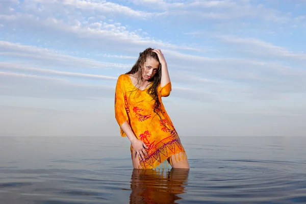 Lány pózol a vízben naplementekor — Stock Fotó