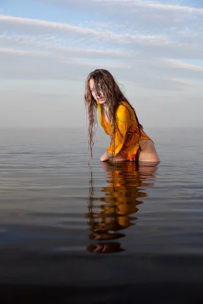 Chica posando en el agua al atardecer —  Fotos de Stock