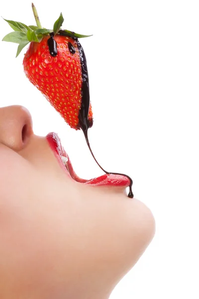 Menina comendo morango com molho de chocolate Fotos De Bancos De Imagens Sem Royalties