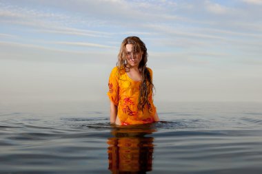 Girl posing in the Water at sunset clipart