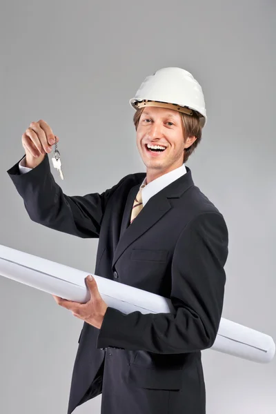 Smiling engineer giving keys from apartment — Stock Photo, Image