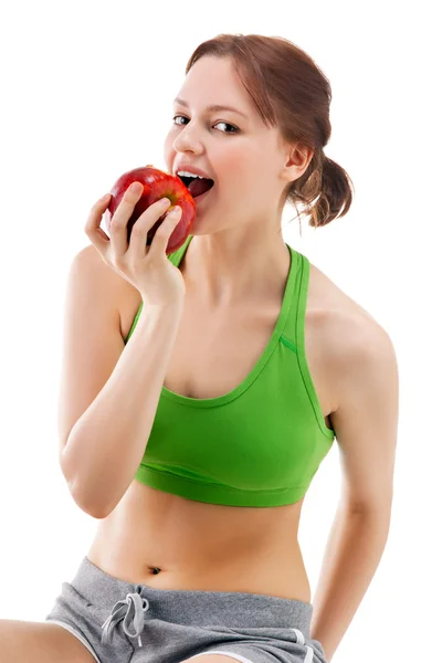 Женщина в спортивной одежде с яблоком — стоковое фото