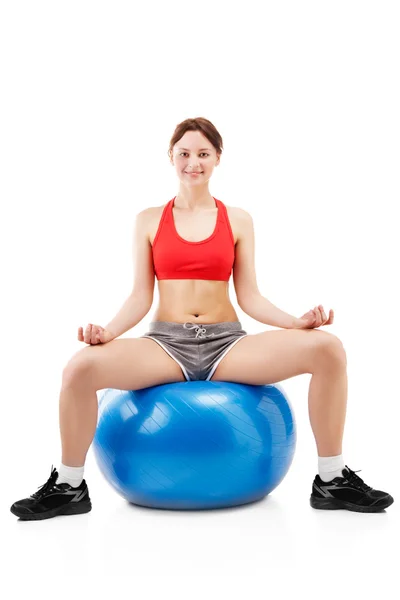 Mulher se exercitando em uma bola de exercício — Fotografia de Stock