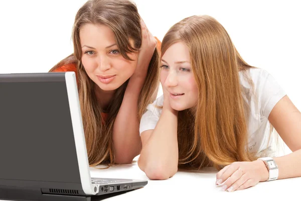 在笔记本电脑上的两个年轻的快乐学生女孩工作 — 图库照片