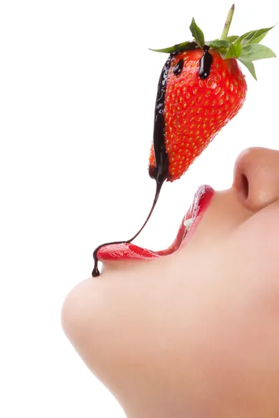Дівчина їсть полуницю з шоколадним тістечком — стокове фото