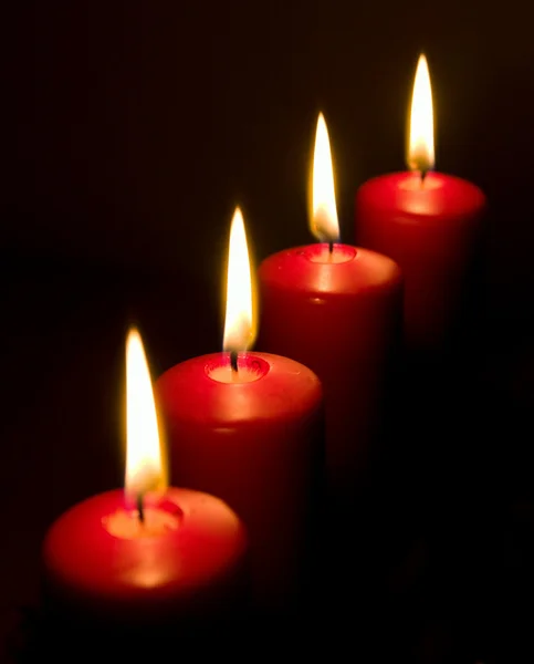 Четыре красные свечи с пламенем — стоковое фото