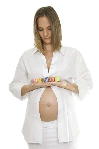 Беременная женщина держит в руках младенческие блоки — стоковое фото