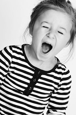 Little cute girl making faces while posing for photographs clipart