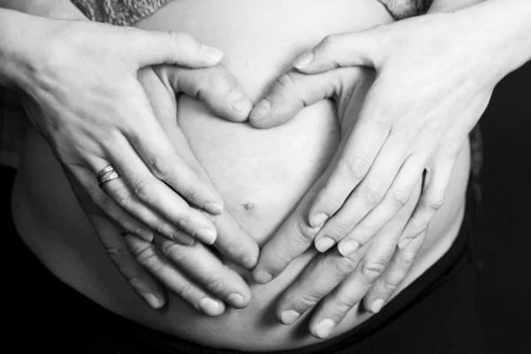 用手在孕妇的肚子上所作的心 — 图库照片