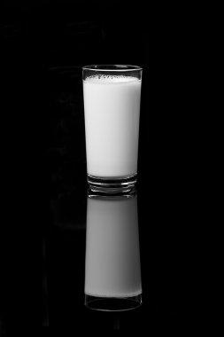 A glass of fresh milk on a black background clipart