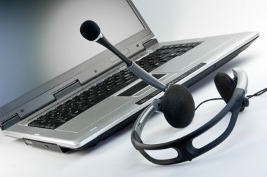 Headset with laptop in the background clipart