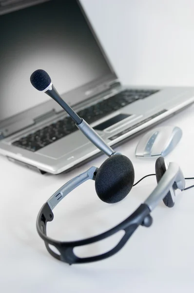 Headset with laptop in the background — Stock Photo, Image