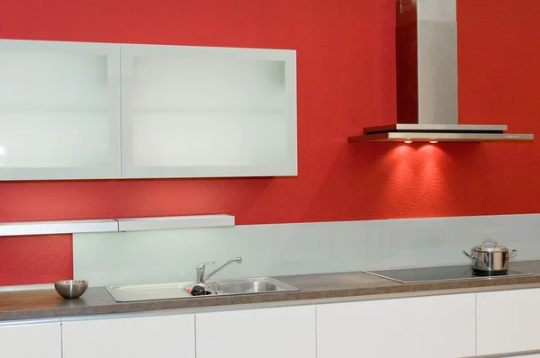 Современная оборудованная кухня с красной стеной — стоковое фото