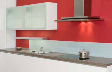 Modern fitted kitchen with red wall clipart