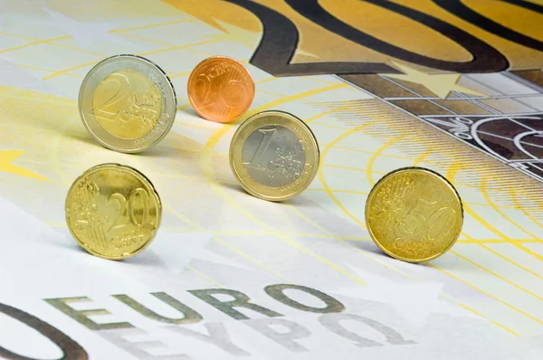 Euro coins 200 euro banknot üzerinde haddeleme — Stok fotoğraf