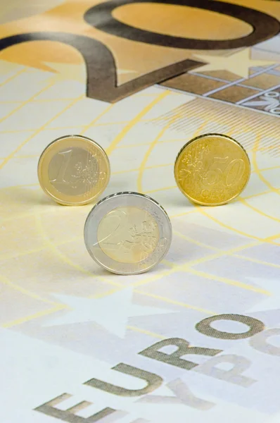 Euro-munten kantelen een 200-euro-biljet — Stockfoto