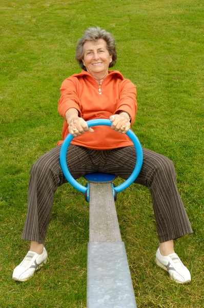 Senior woman on a seesaw — Stock Photo, Image