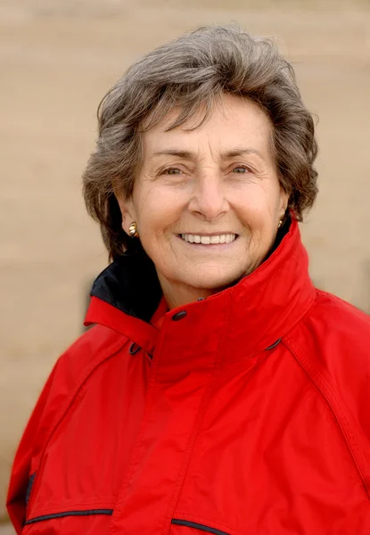 Senior woman with red windbreaker — Stock Photo, Image