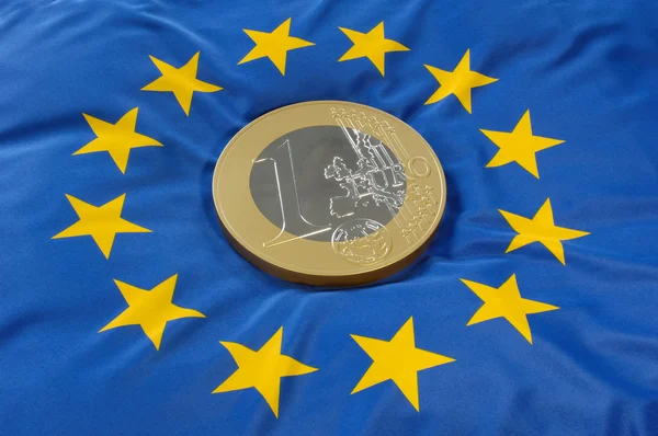 Euro coin on a european flag — Stok fotoğraf