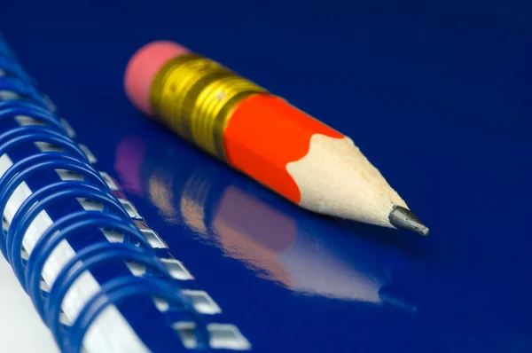 Krótki ołówek na niebieski notatnik — Zdjęcie stockowe