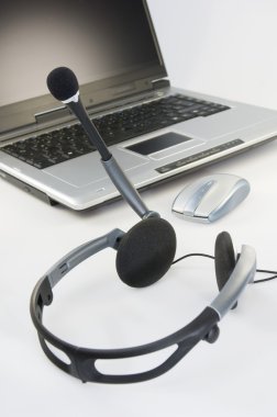Headset with laptop in the background clipart
