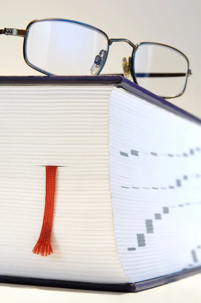 Thick book with red bookmark and reading-glasses — Stock Photo, Image