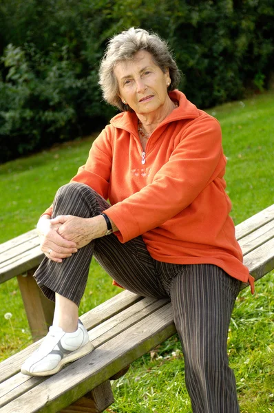 Older woman on a bench in the park — Stock Photo, Image