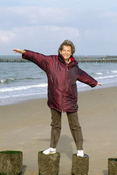 Happy active senior woman on a beach walk — Stock Photo, Image