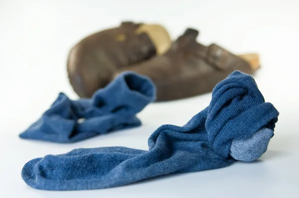 Chaussettes et sandales usées et sales sur le sol — Photo