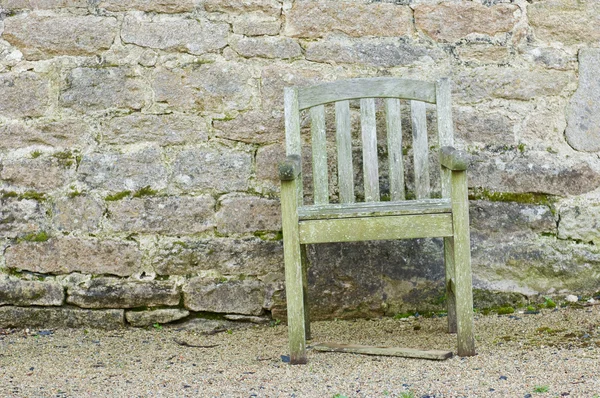 Sedia da giardino marcio di fronte a un muro di mattoni — Foto Stock