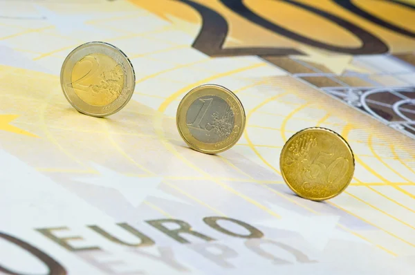 Pièces en euros roulées sur un billet en euros — Photo