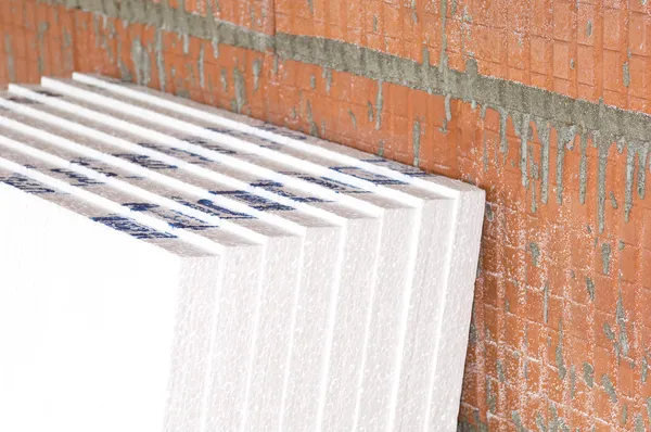 Изоляционные доски у стены на строительной площадке — стоковое фото