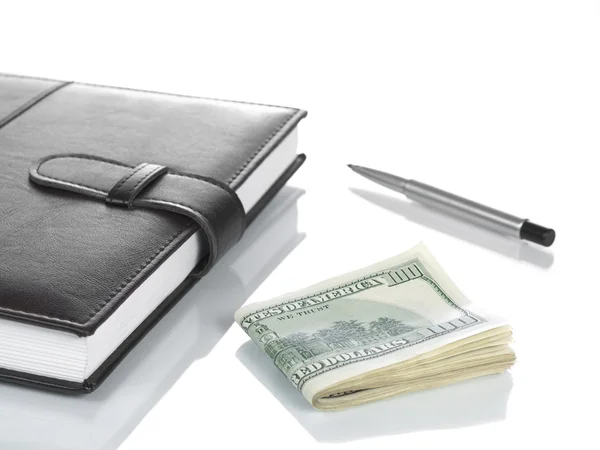 Booknote, dolarów i pióra. — Zdjęcie stockowe