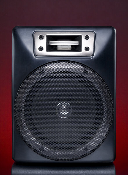 A black speaker over a red background.