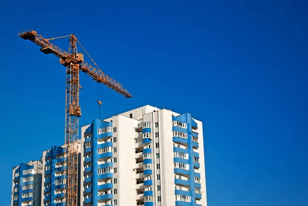 青空の背景と集合住宅のフラグメントに黄色いクレーン — ストック写真