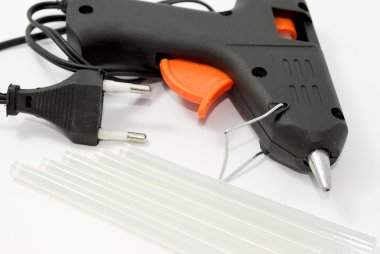 Glue gun with the glue sticks, tools on a white background. clipart