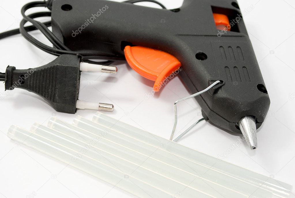 Glue gun with the glue sticks, tools on a white background.