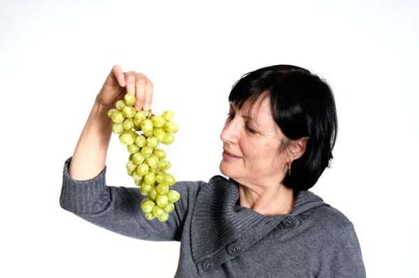 Aged woman with grapes — Stock Photo, Image