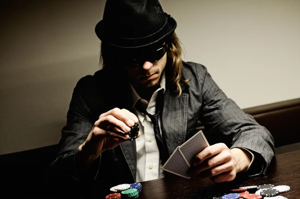 玩地下扑克的眼镜和帽子的男人 — 图库照片