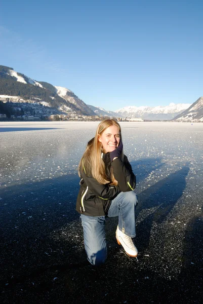 阳光明媚的日子在结冰的湖面上滑冰的年轻女子冰 — 图库照片