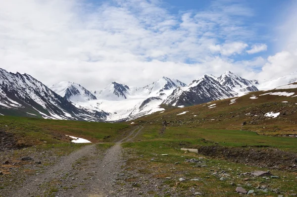 Красочные горы с дорогой, снегом, небом и облаками — стоковое фото
