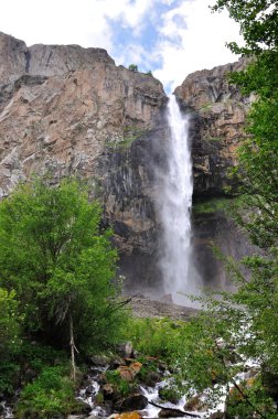 Waterfall in mountains with sky and clouds clipart