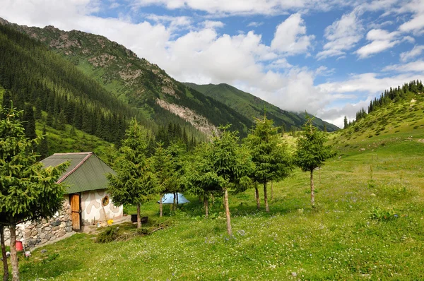 Colorful mountain hut in Altyn-Arashan gorge with sky and clouds — Stock Photo, Image