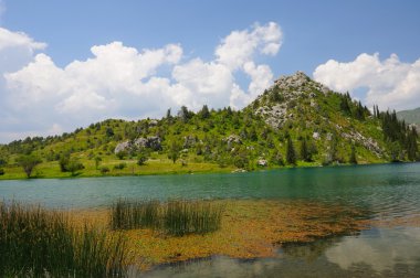 Colorful lake with mountains, sky and clouds clipart