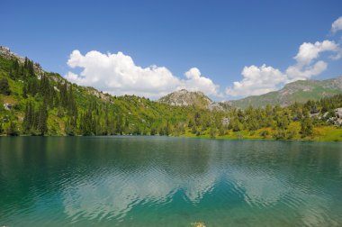 Colorful lake with mountains, sky and clouds clipart