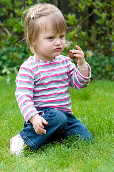 女の赤ちゃんはお菓子を食べています。 — ストック写真
