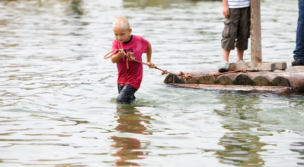 Young boy is pulling a raft — Stock Photo, Image