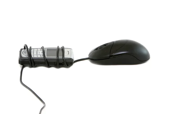 有線のコンピューターのマウスを使って携帯電話. — ストック写真