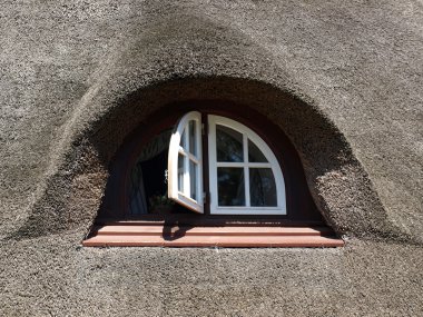 güzel bir ev ve bir kamış çatı penceresinde