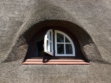 Nice window in a house with a reed roof clipart